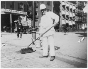 Person sweeping street | A Brief History on Street Sweepers | Wafer Brushes used by New York City Street Sweepers | Smith Equipment
